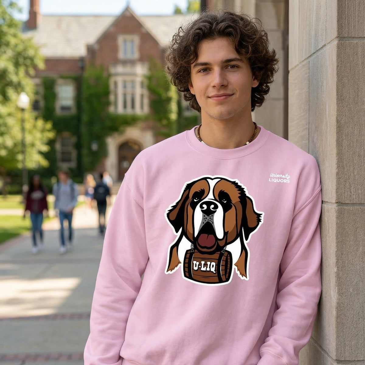 Person wearing a light pink University Liquors sweatshirt in an outdoor setting