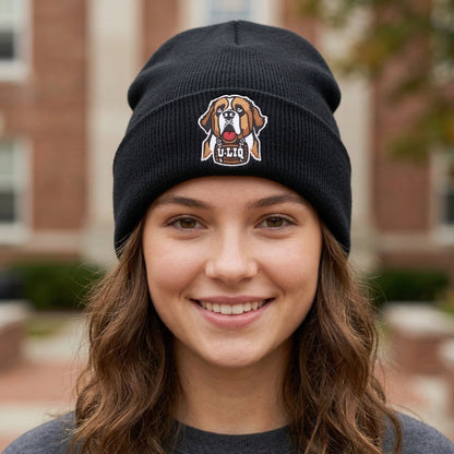Person wearing a black beanie with a University Liquors logo in front of a brick building