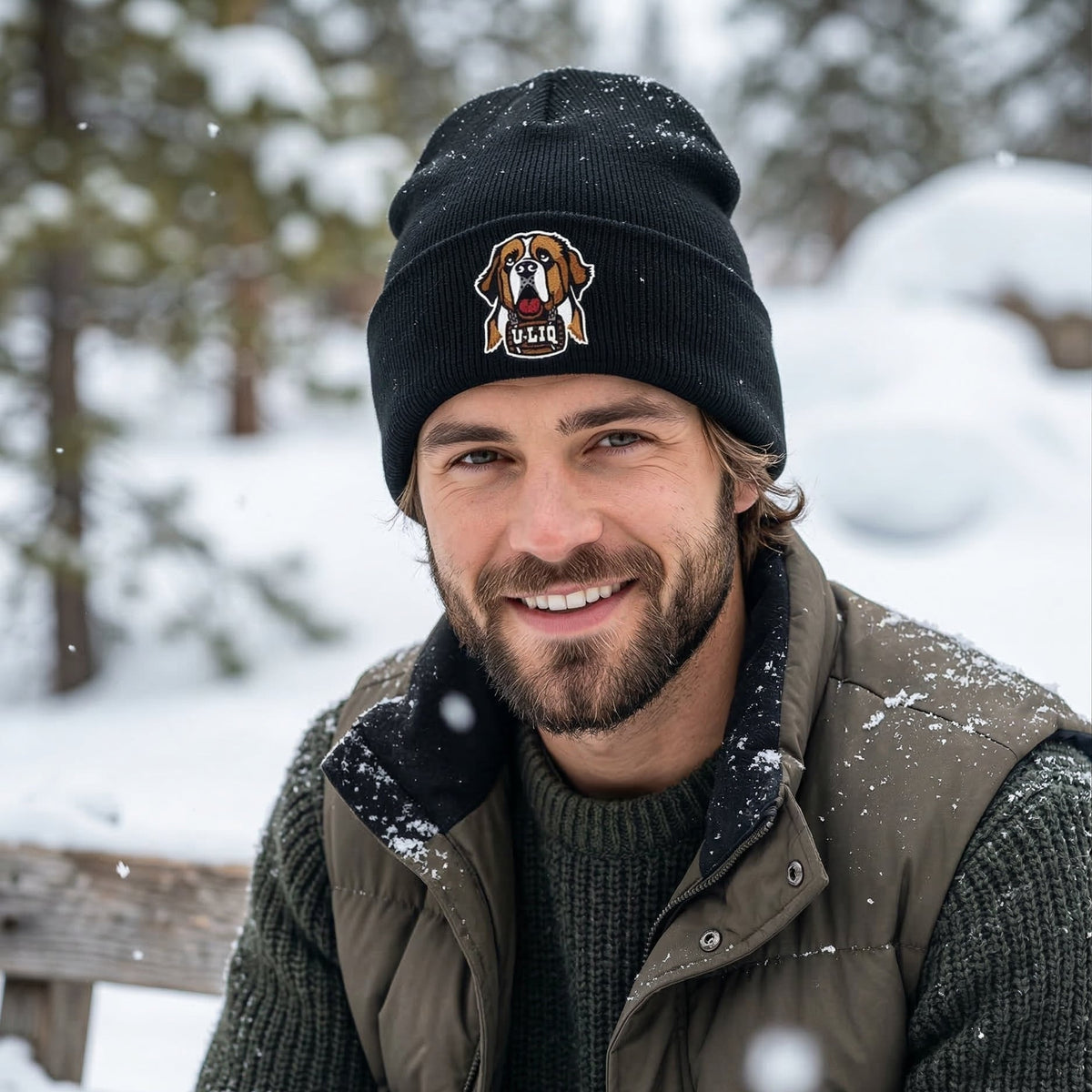 Man wearing a black beanie with a University Liquors logo in a snowy outdoor setting