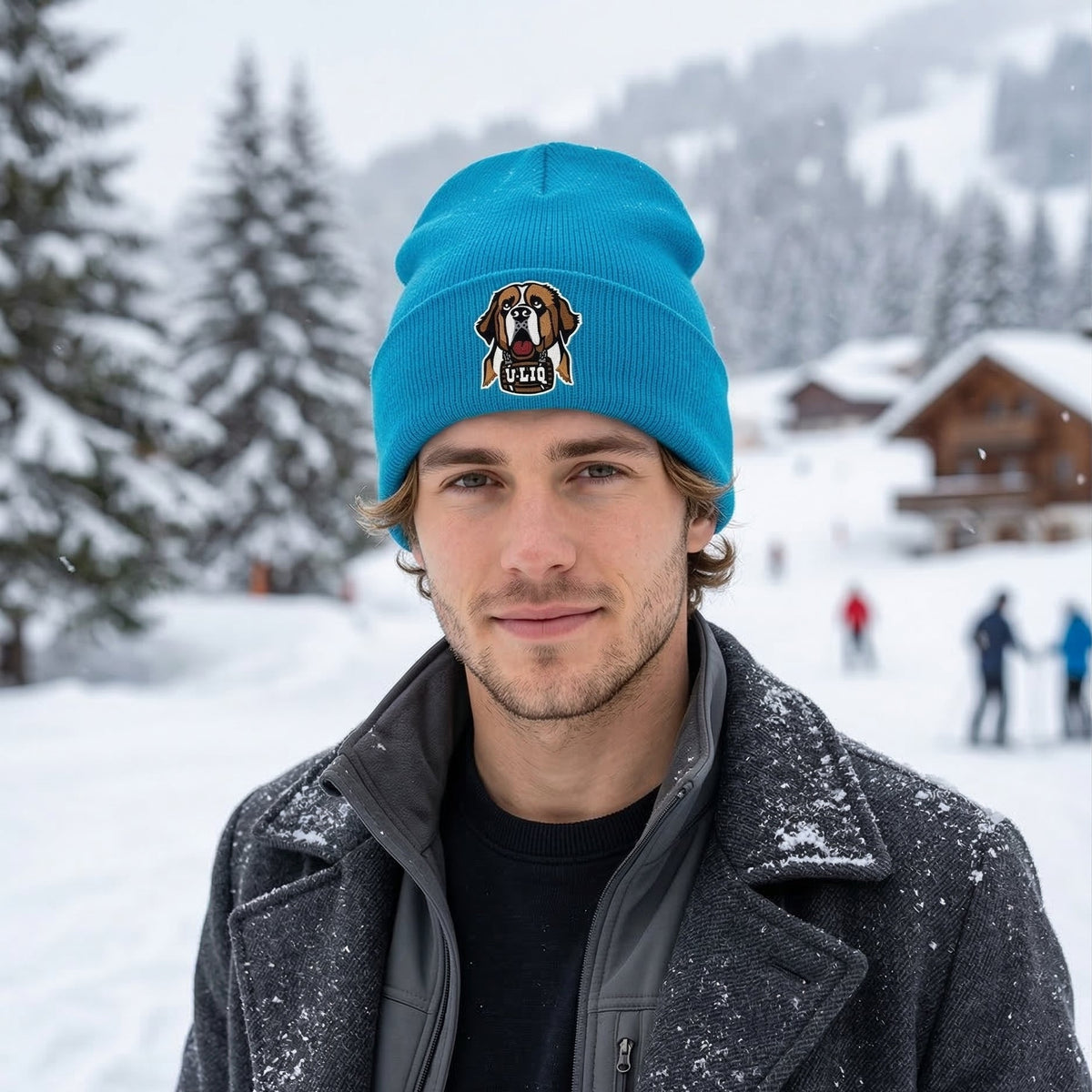 Man wearing a blue beanie with a University Liquors logo in a snowy landscape