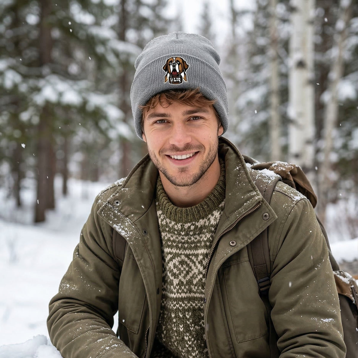 Man in winter clothing sitting in a snowy forest