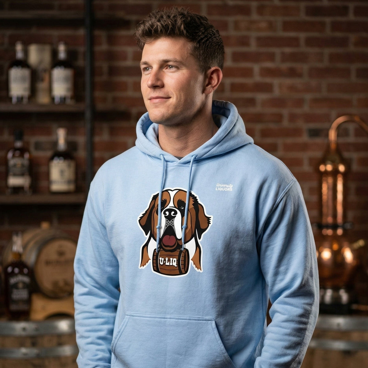 Man wearing a light blue University Liquors hoodie with in a bar setting.