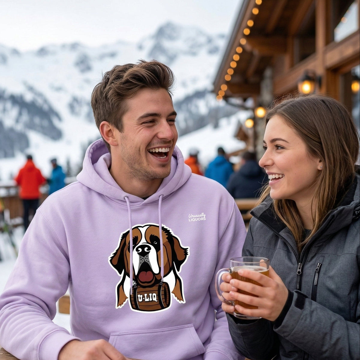 Two people sitting at a wooden table in a snowy mountain setting, one wearing a orchid University Liquors hoodie.